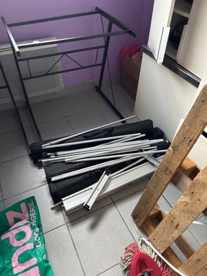 un tas de métal et de bois posé par terre dans une pièce
