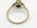 a close up of a gold ring with a black stone