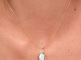 un gros plan d'une femme portant un collier avec un pendentif en forme de cœur