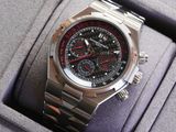 montre argentée et rouge dans un coffret, avec un bracelet noir et rouge