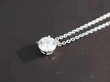 a close up of a diamond necklace on a black surface