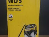 un carton contenant un aspirateur posé sur une table en bois