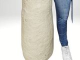 woman standing next to a large roll of jute rope