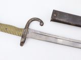 an old knife with a wooden handle sitting on top of a white surface