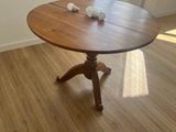 a wooden table in the middle of a room with a window