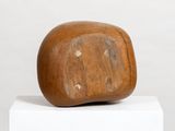 wooden sculpture of a rock on a pedestal on a white surface