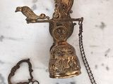 a brass bell with a chain around it on a marble surface