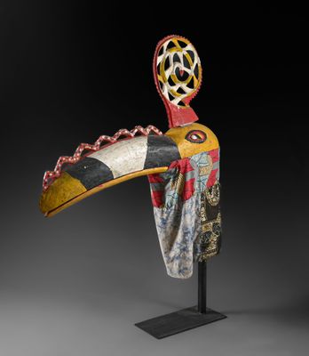 une sculpture en bois représentant un oiseau, posée sur un socle