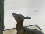 a statue of a man standing next to a statue of a deer