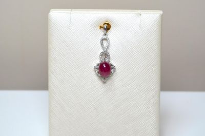 Un pendentif en argent 925 millièmes serti d'un rubis caboch…