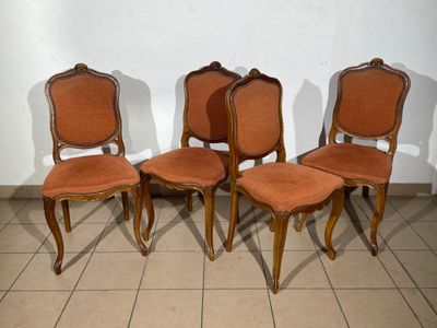 four chairs are lined up in a row on a tiled floor