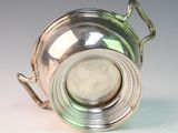 a silver cup with a handle on a white surface