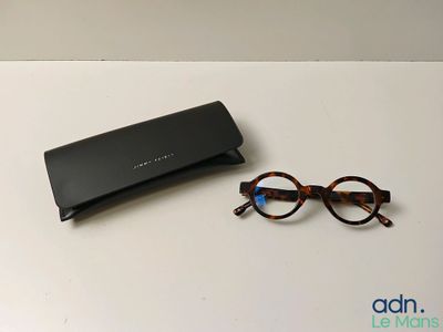 des lunettes de soleil et une paire de lunettes posées sur une table, avec un étui noir