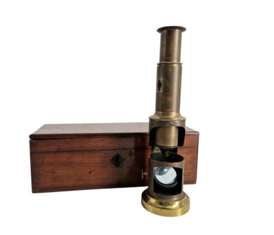 un vieux télescope en laiton dans un coffret en bois, sur fond blanc