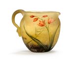 a yellow vase with flowers painted on it