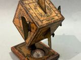 a small wooden clock on a stand on a white surface