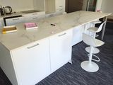 an image of a kitchen with a marble counter top and bar stools