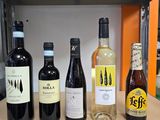 several bottles of wine are lined up on a shelf in a kitchen