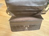 brown leather purse on wooden floor next to wooden floor