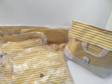 yellow and white striped bags are lined up on a table