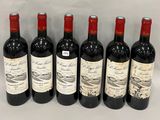 six bottles of red wine lined up in a row on a table
