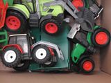 a lot of toy tractors in a box on the floor