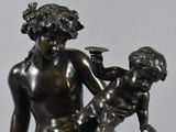 bronze statue of a woman holding a child on her lap