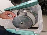 a person that is holding a circular blade in a box