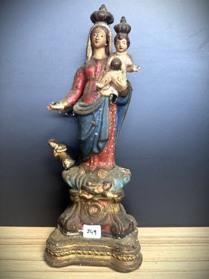 statue of a woman holding a child and a bird on a table