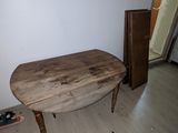 a wooden table in the middle of a room with a skateboard on the floor