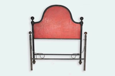 un lit avec une tête de lit rouge et un cadre en métal