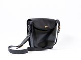 black leather cross body bag with shoulder strap on a white background