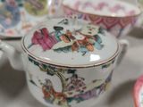 several different types of porcelain bowls and saucers on a table