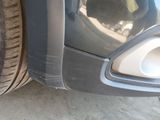 a close up view of a car ' s front bumper and tire