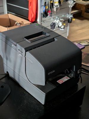 une imprimante posée sur un bureau, à côté d'une souris d'ordinateur