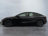 the tesla model 3 is parked in a room with a white wall