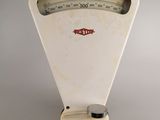 an old white scale sitting on top of a white table
