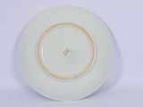a white plate with a brown rim on a white surface