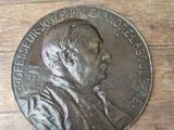 a silver medal with a picture of a man on it