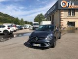 La voiture noire est garée devant l'immeuble, sur le parking.
