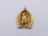 a close up of a gold pendant with an eagle on it