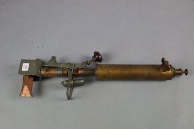 an old brass pipe with a brass handle on a gray surface