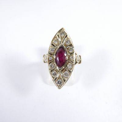 a close up of a ring with a ruby stone surrounded by diamonds