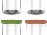 four glass containers with different colors of lids on a white background