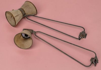 three old fashioned metal objects on a pink surface