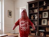 a large red penguin statue on a table in a room