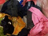 a pile of clothes sitting on top of a bed