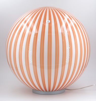 a large orange and white striped lamp on a table