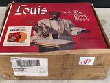 une boîte sur laquelle figurent une photo de Louis et le livre « The Dead »