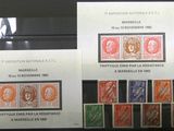 Plusieurs timbres différents sont exposés dans une vitrine.